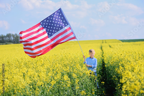 Happy child with the flag of the United States of America, back view, whole body, outdoor. photo