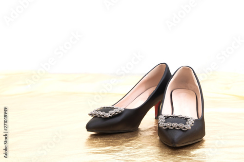 Pair of beautiful high heels shoes with copy space on golden and white background