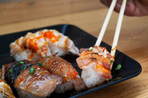 Close up fresh homemade sushi with chopsticks on plate. photo