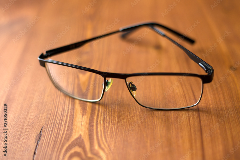 glasses with transparent lenses to improve vision on a wooden background close-up glasses with transparent lenses to improve vision on a wooden background close-up