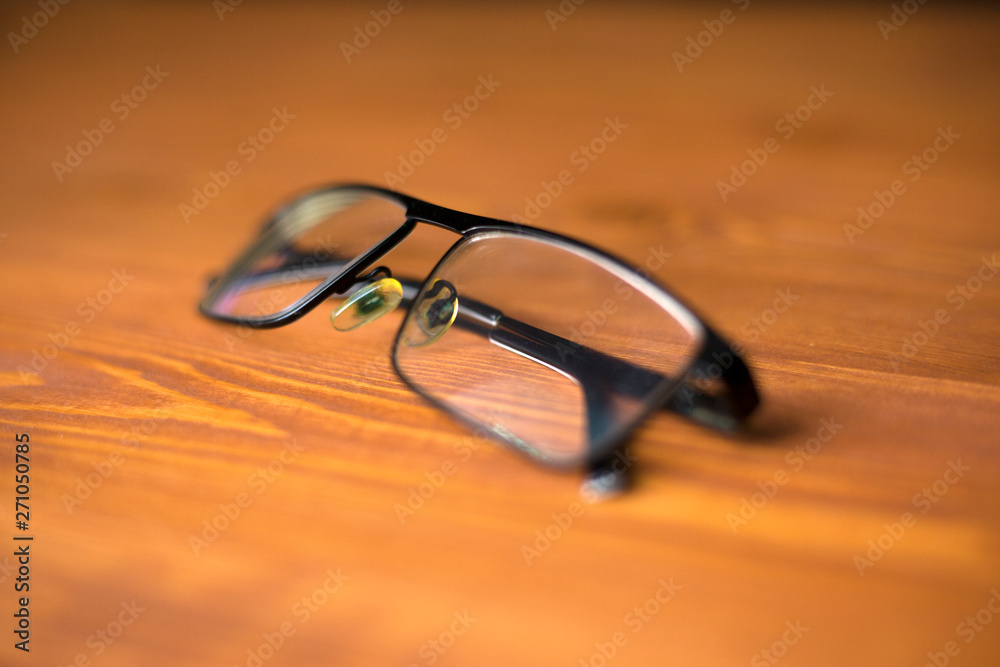 glasses with transparent lenses to improve vision on a wooden background close-up 