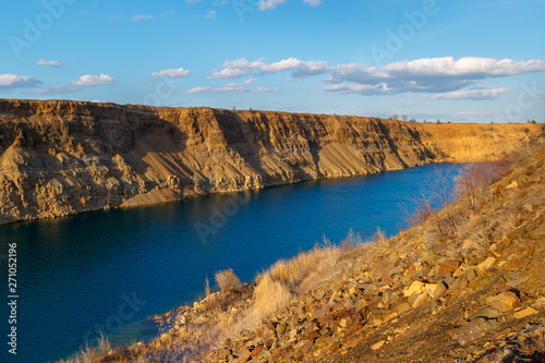 The deep blue artificial lake on the bottom of the old abandoned stone quarry
