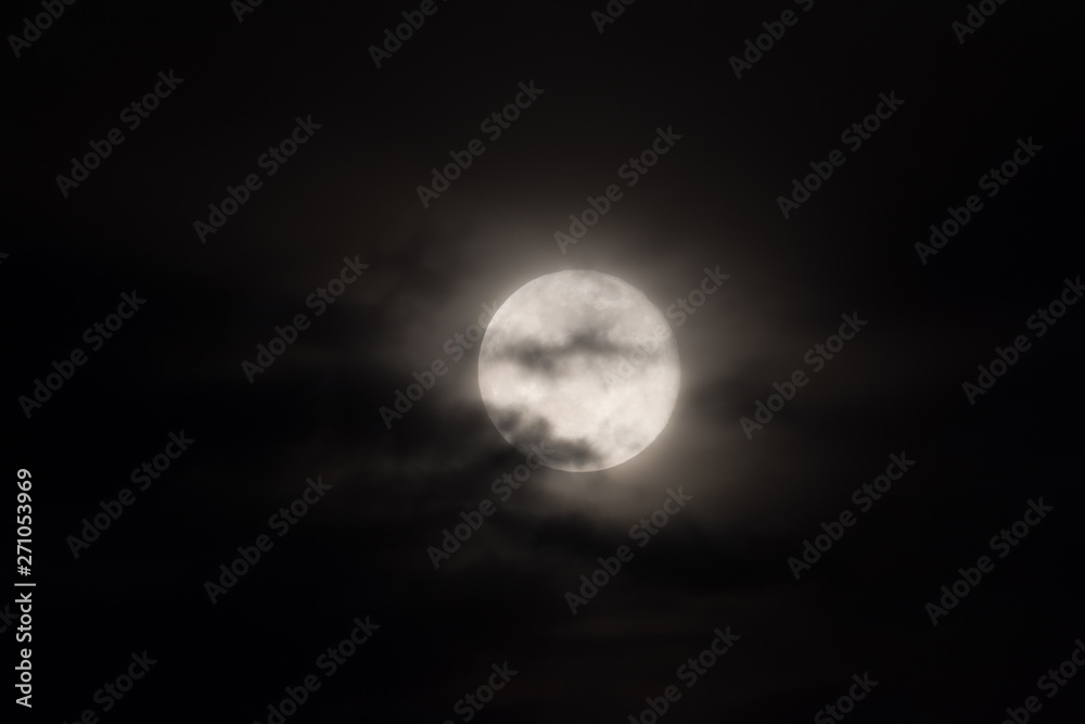 full moon under heavy clouds