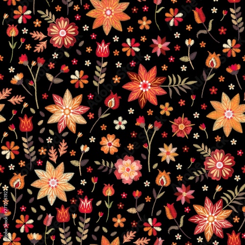 Embroidery seamless pattern in folk style. Stylized flowers and leaves on black background. Vector illustration. Fashion design.