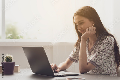 Young woman working with her laptop at home