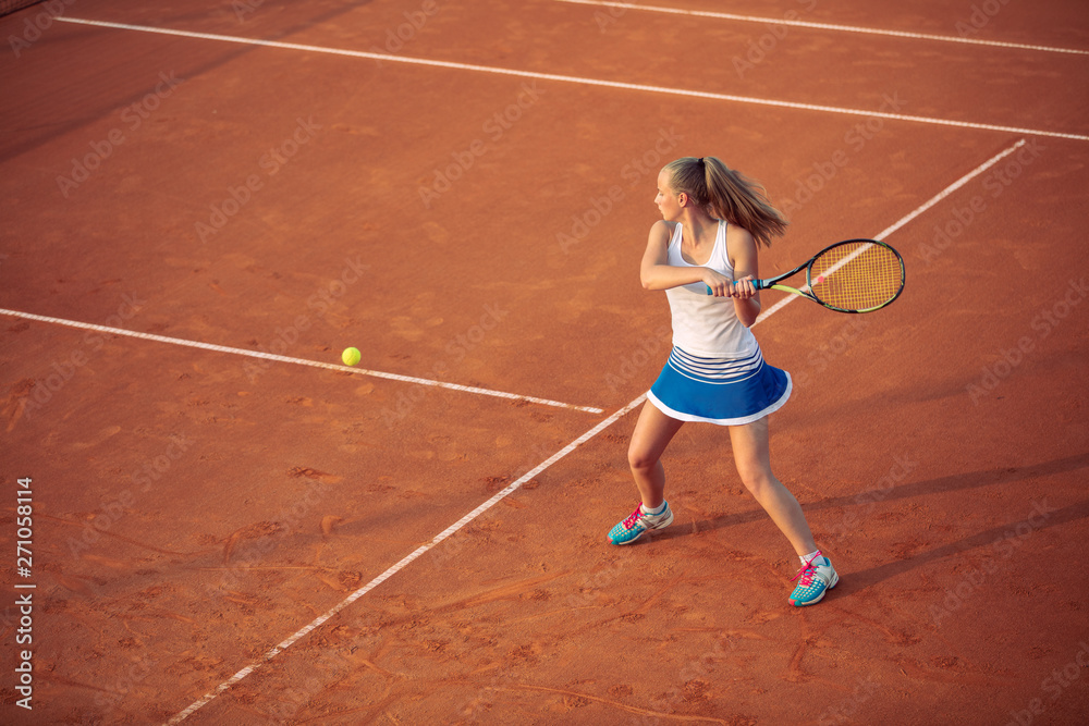 Woman playing tennis on clay court, with sporty outfit and healthy lifestyle