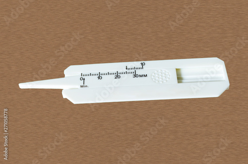 Close up of Tire tread depth gauge isolated on wooden background.