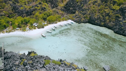 Rest time on star beach on Tapiutan island near Matinloc shrine. El Nido, Palawan, Philippines. Many boats of tour C stops here for lunch photo