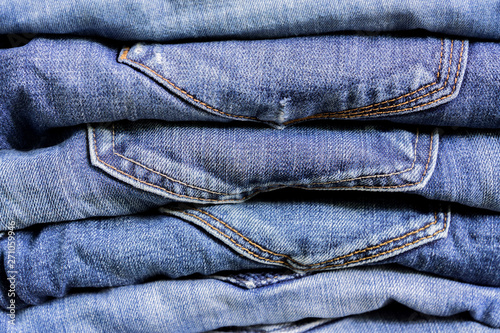 Stack of blue jeans background texture. Beauty and fashion clothing concept