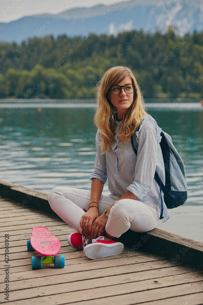Attractive girl holding her penny board outdoors.