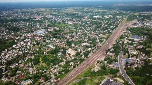 Aerial, high, drone shot, over a village and towards railway tracks, in Naujoji Vilnia, on a sunny summer day, near Vilnius, Lithuania photo