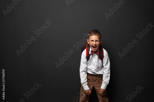 portrait of an emotional child. boy schoolboy screams splashes out negative emotions. the concept of student shouts no desire to vozvrashatsa to school. don't want to learn