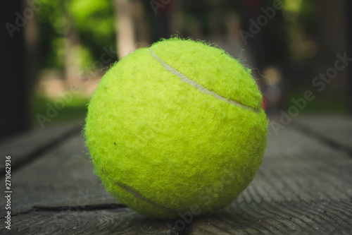 yellow tennis ball with a racket on the street court