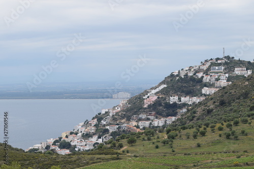 View of the sea and a small town on a hill near the coast.