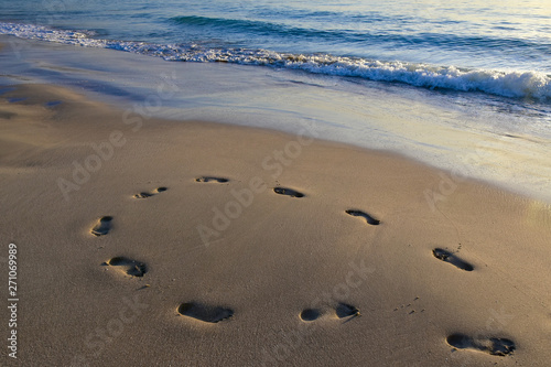 Obraz na płótnie footprints in the sand from the feet of a lost person. no way out of the situation. return to the be w salonie