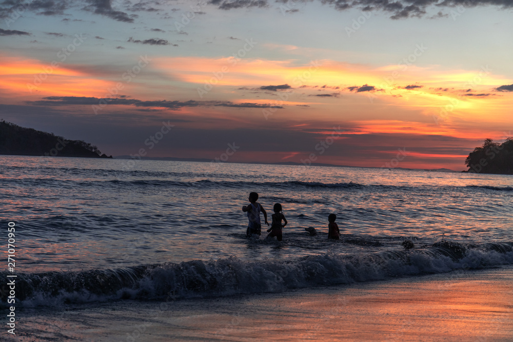 Kinder spielen am Strand beim Sonnenuntergang in Panama Kinder spielen am Strand beim Sonnenuntergang in Panama