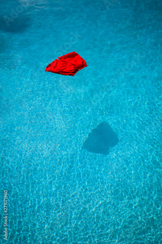 red swimming trunks floating on a swimming pool - Caught With Your Pants Down