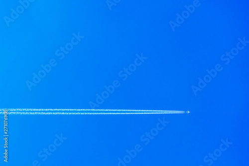 ..Airplane with contrail in the blue sky. The concept of freedom, moving forward. Sky background. Forward to 2020.