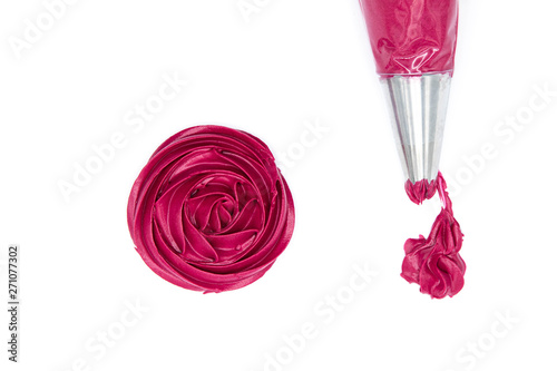 Squeeze the cake decorating cream into red roses on a white background.