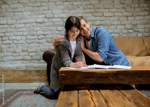 Father and daughter doing homework at home