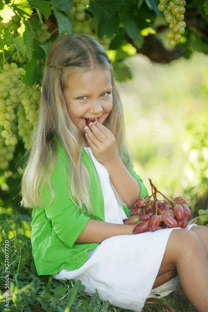 Fototapeta premium Child with grapes in nature 