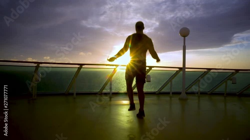 Sportsman makes an exercise with a jumping rope during sunrise photo