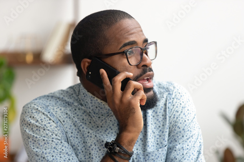 Fotótapéta Close up african-american employee talking phone at workplace in office