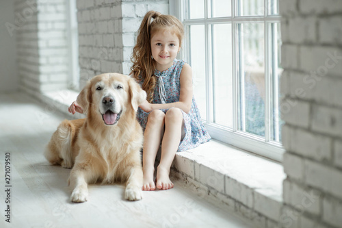 A child with an animal. Little girl with a dog at home.  © nuzza11