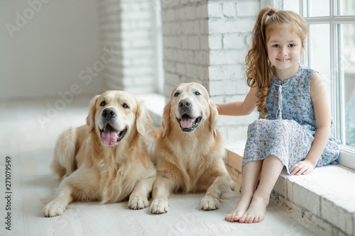 A child with an animal. Little girl with a dog at home. 