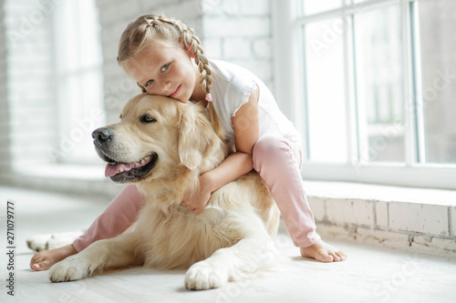 A child with a dog at home. 