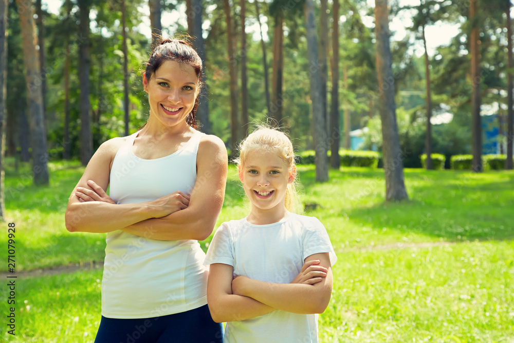 Fototapeta premium sporty mother and daughter. woman and child training. outdoor sports and fitness family