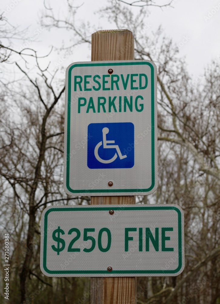 A reserved handicap parking sign on the wood post.