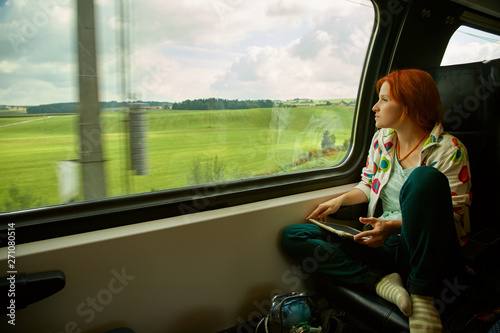 woman using tablet computer on train. traveler on the road