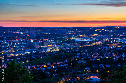 Germany, Magical illuminated skyline of houses downtown stuttgart bad canstatt and famous arena from above after sunset
