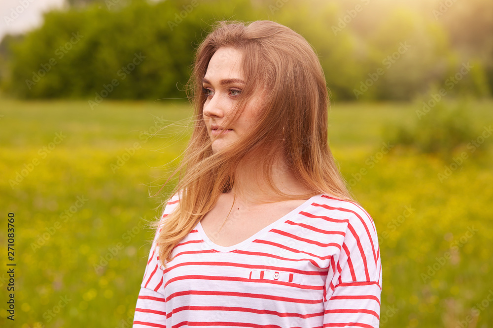 Profile of cute girl posing outdoors, beautiful woman spending summer holiday in meadow, happy female enjoying summer and good weather, young being photographed in field, pretty teen relaxed outside. Profile of cute girl posing outdoors, beautiful woman spending summer holiday in meadow, happy female enjoying summer and good weather, young being photographed in field, pretty teen relaxed outside.