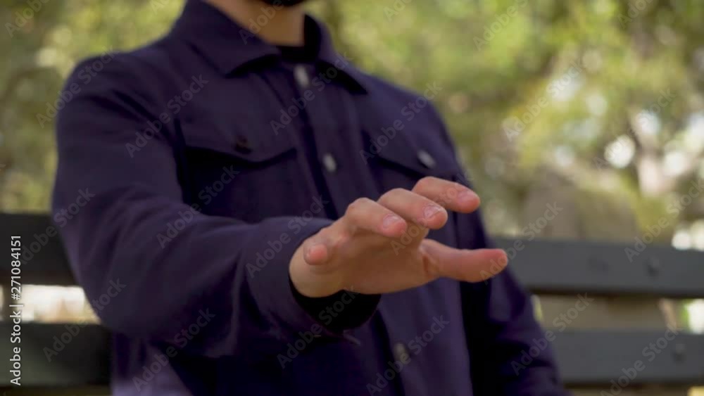 Hand of man sitting on the bench in a park man waving his hand in the air imagining that he presses the keys Hand of man sitting on the bench in a park man waving his hand in the air imagining that he presses the keys