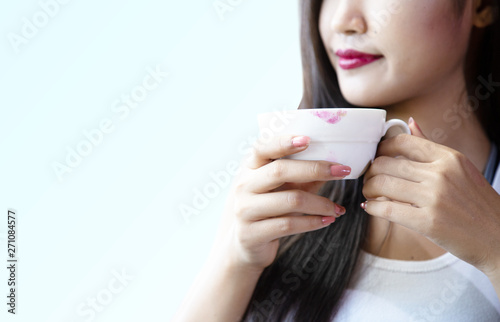 Young women are drinking hot coffee happily.