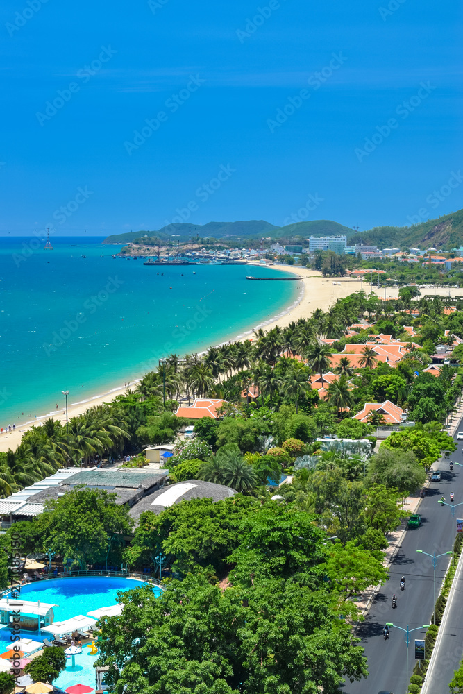 Aerial viewof resort on tropical beach on shore with green park and blue water