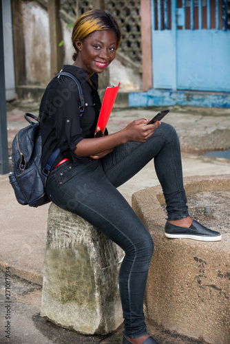 young student with mobile phone, smiling.