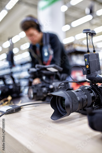 Videographer shooting a film or a television program in a studio with a professional camera, backstage