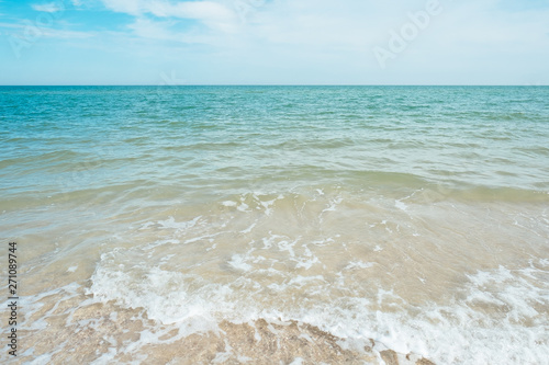 Blue turquoise sea waves with sand and sky clouds