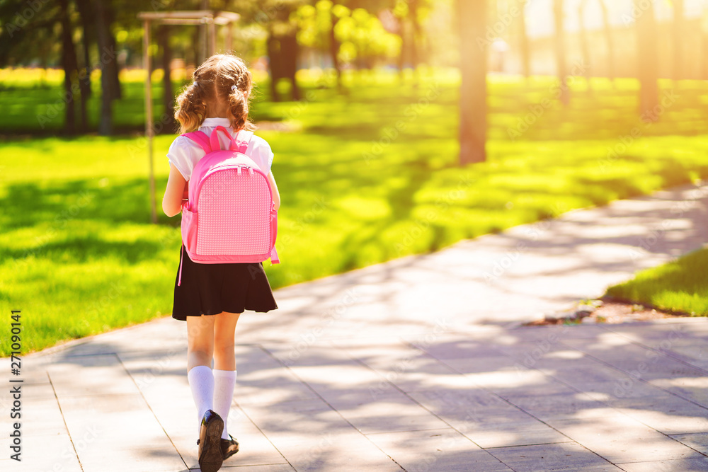 Beautiful little girl with backpack walking in the park ready back to ...