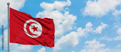 Photo Tunisia flag waving in the wind against white cloudy blue sky