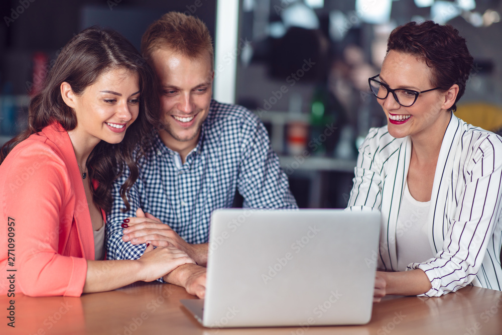 Investment adviser giving a presentation to a friendly smiling young couple seated at her desk in the office Investment adviser giving a presentation to a friendly smiling young couple seated at her desk in the office