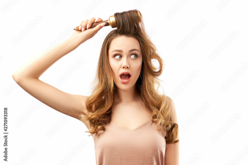 surprised shocked young woman with long beautiful hair, combs them and open her mouth in amazement. the concept of hair care surprised shocked young woman with long beautiful hair, combs them and open her mouth in amazement. the concept of hair care