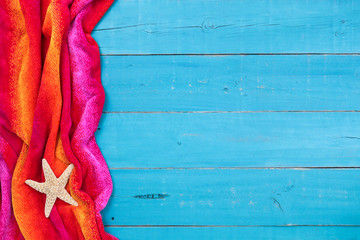 Blank teal blue wood sign with red beach towel and starfish border