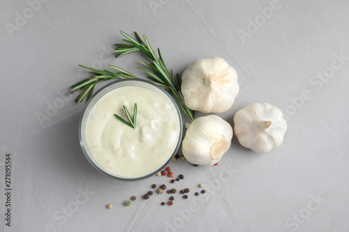 Flat lay composition with garlic sauce on grey background photo