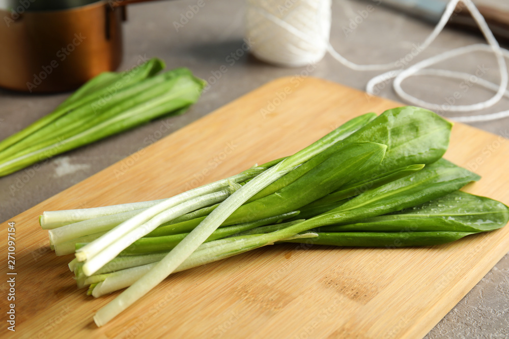 Board with wild garlic or ramson on grey table, closeup Board with wild garlic or ramson on grey table, closeup