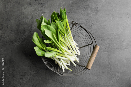 Basket with wild garlic or ramson on grey table, top view photo