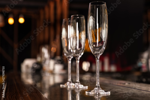 Empty clean champagne glasses on counter in bar. Space for text